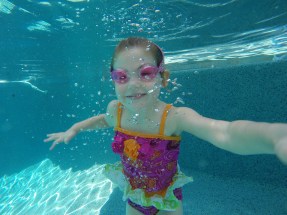 Zoe- Age 4 Taking a quick break from swimming across the pool to smile for the camera!
